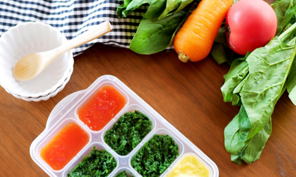 離乳食と一緒に野菜が並んでいるイメージ