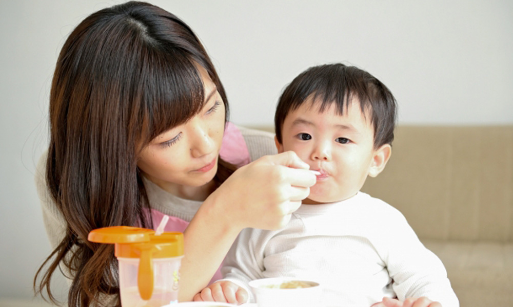 離乳食を与えるタイミングと、皮膚の状態をチェックしている保護者のイラスト