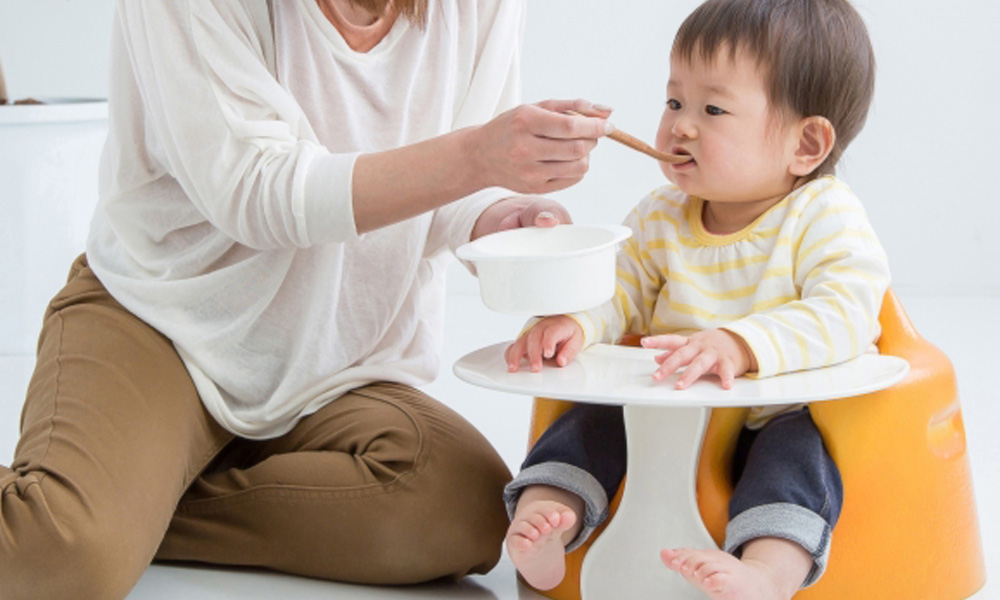 子供に離乳食を食べさせる母親のイメージ