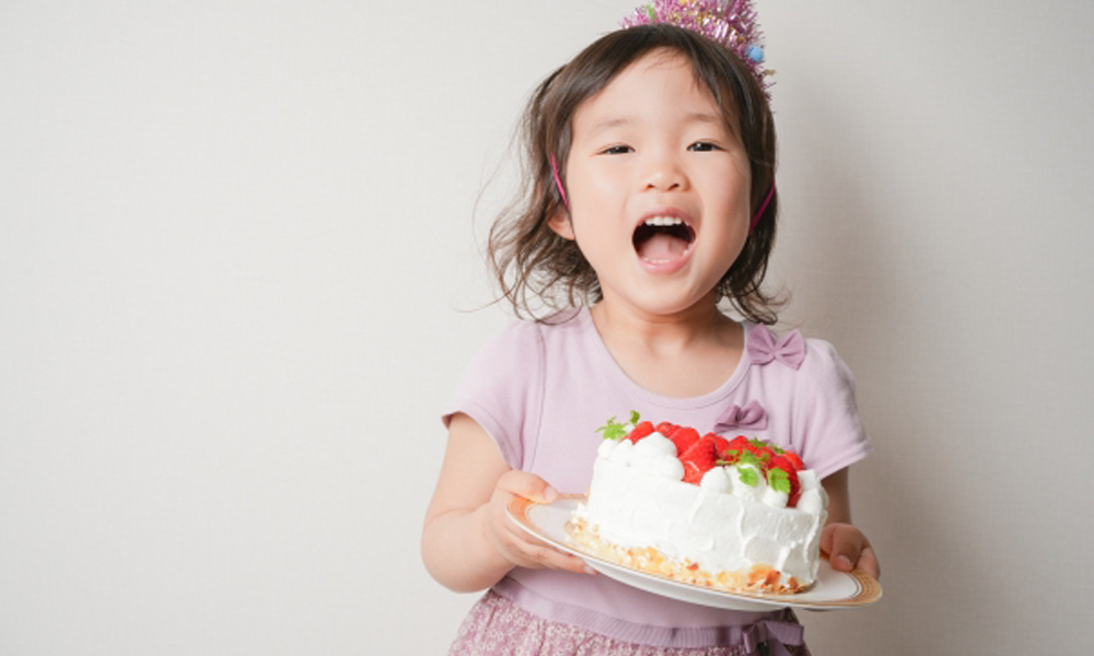 生クリームたっぷりのケーキを持っている女の子のイメージ