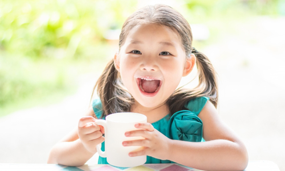 牛乳を飲んで喜んでいる女の子のイメージ