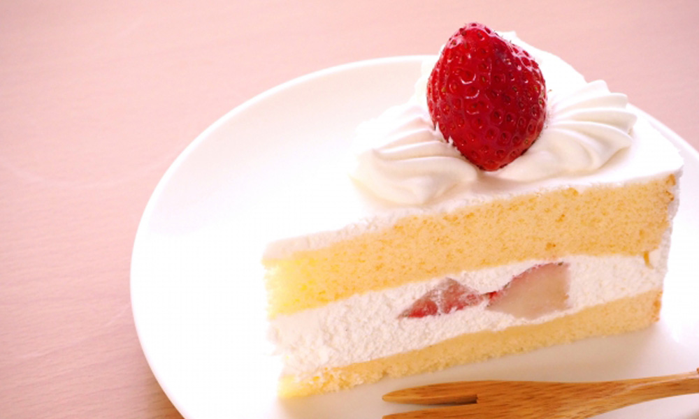 生クリームがたっぷりのイチゴがのったショートケーキのイメージ