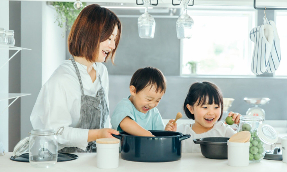 キッチンで子供と一緒に料理を楽しむママのイメージ
