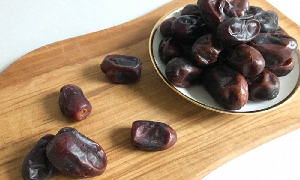 木のプレートの上にたっぷり盛り付けられたデーツのイメージ