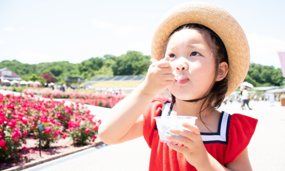 外で美味しそうにアイスクリームを食べる子供のイメージ