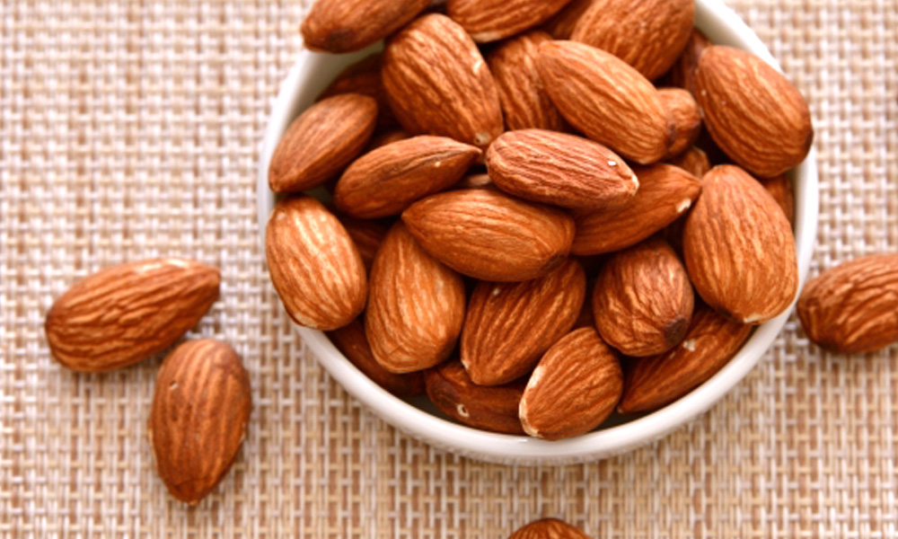 お皿にたっぷり入った素焼きアーモンドのイメージ