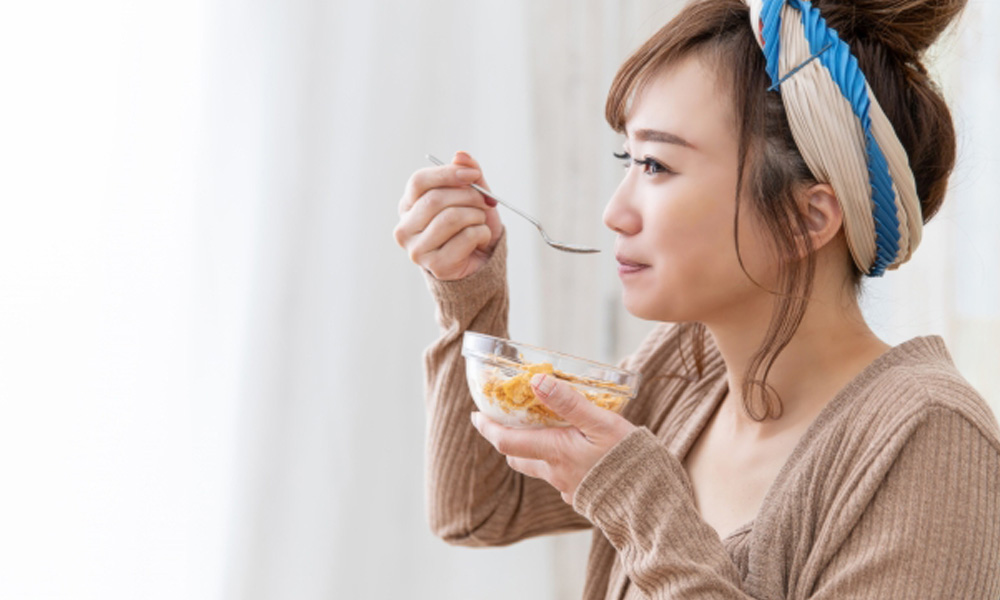 シリアルを食べる健康的な女性のイメージ