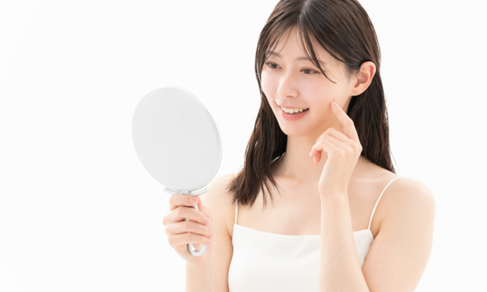 健康と美容を意識し鏡を見て確認をする女性のイメージ