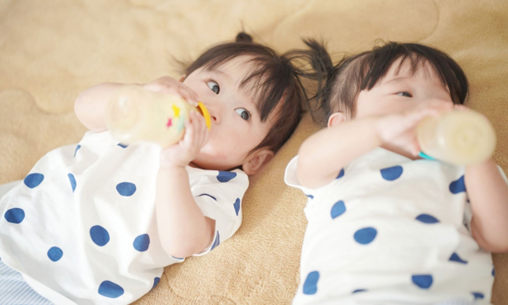 哺乳瓶を加えてミルクを飲む子供のイメージ