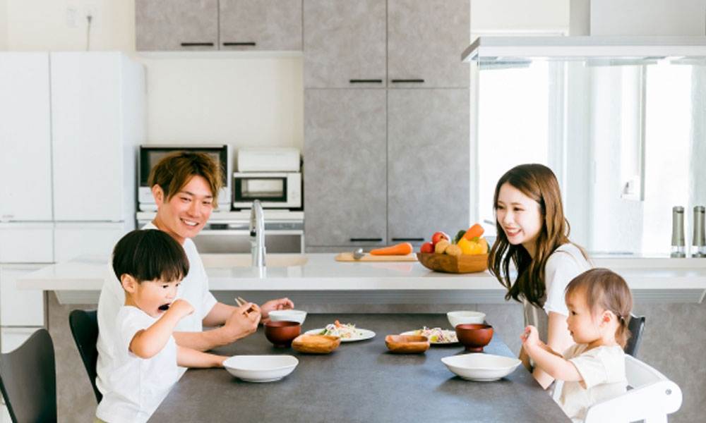子供と両親の家族でご飯を食べるイメージ