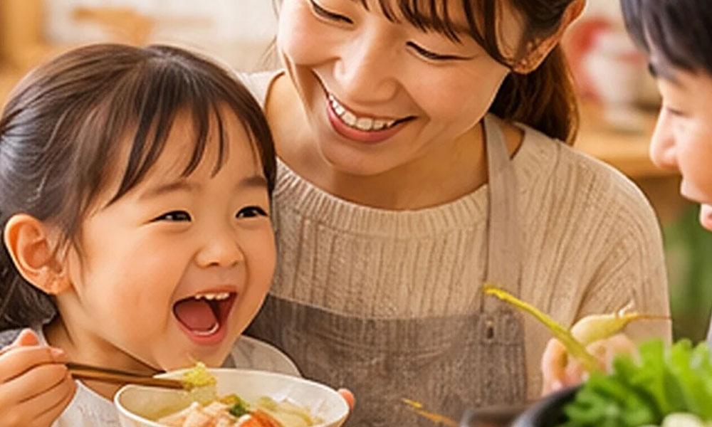 親子で鍋料理を取り分けながら食事を楽しむ様子